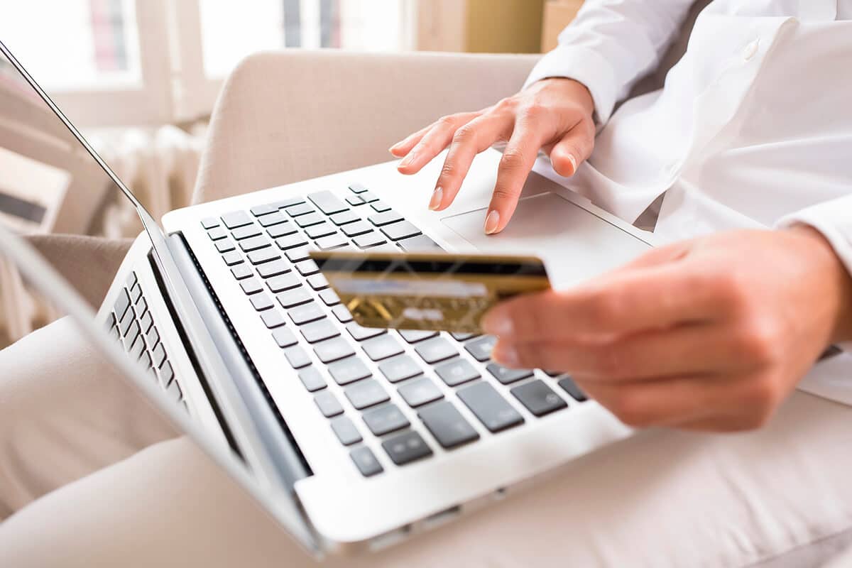 Person online einkaufend mit Laptop und Kreditkarte
