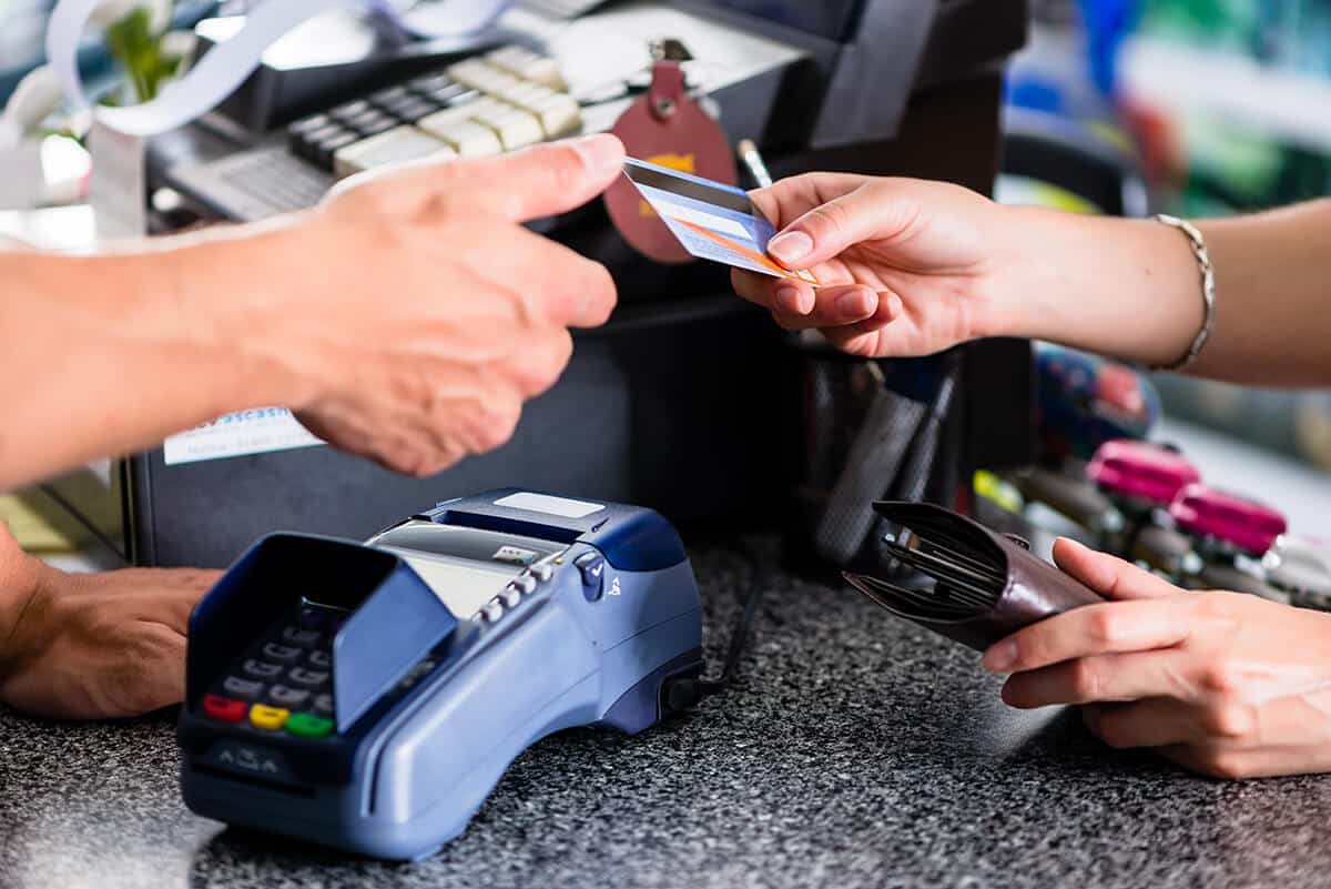 Zahlungslösungen in der Schweiz: Ein Überblick über 8 Anbieter und ihre Vor- und Nachteile Person zahlt mit Karte am POS-Terminal
